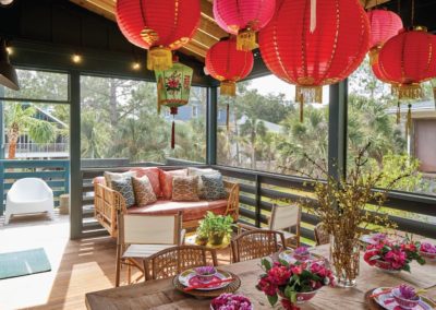 Screen porch with couch and Asian hanging lanterns at 405 West Indian Avenue on Folly Beach