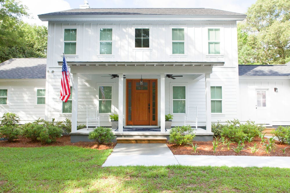 Bright wooden front door and American flag of the Ricks plan