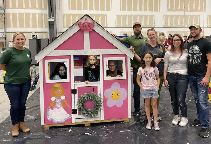 The New Leaf team stands with Naomi and her custom built playhouse